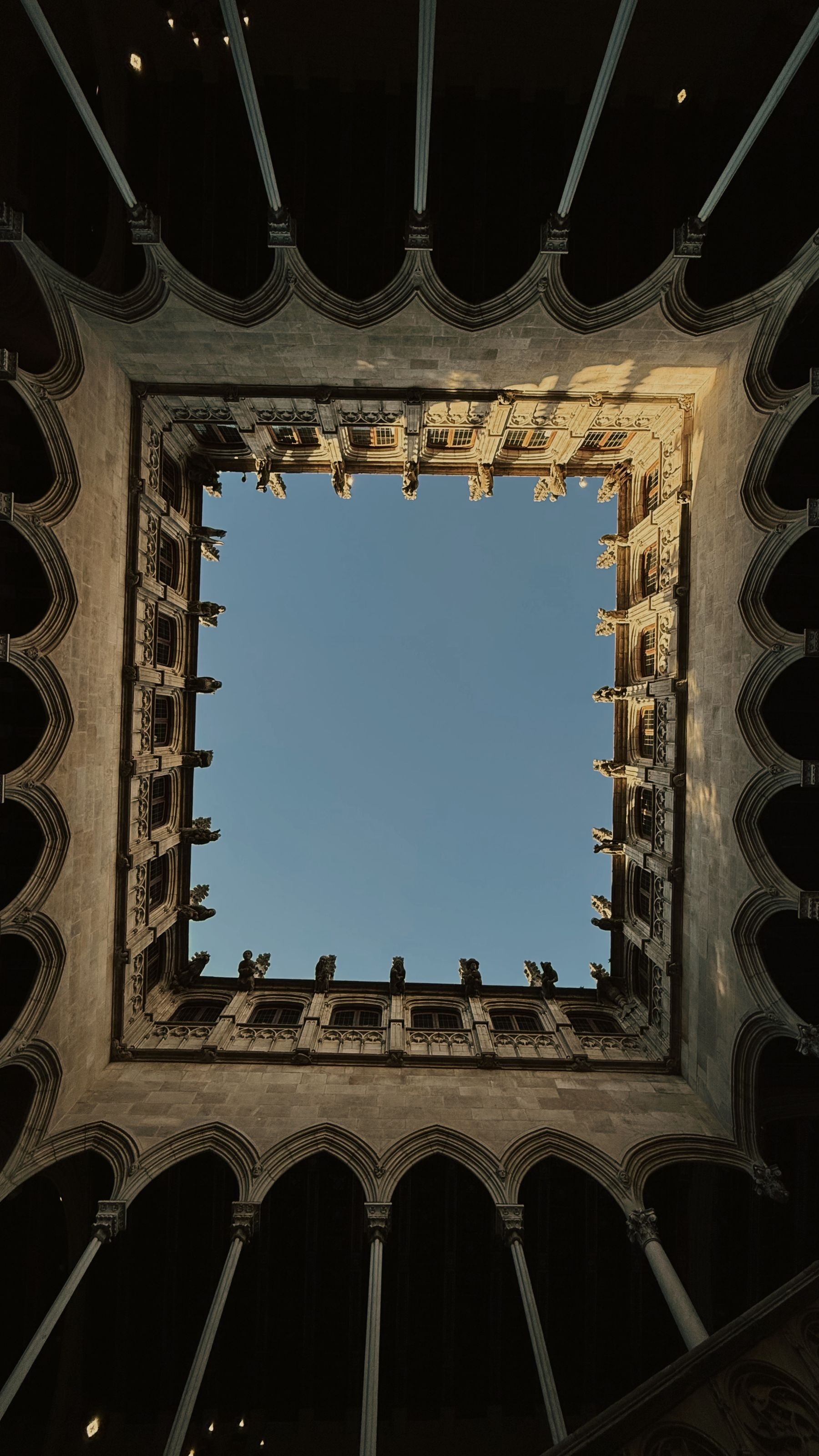 Stone courtyard of a historic building framing the sky